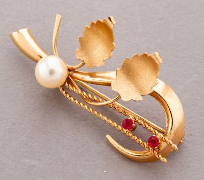 an image of a gold brooch with pearls and leaves