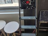 deux tabourets et une échelle dans un coin de la pièce