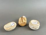 three small vases sitting on top of a table next to each other