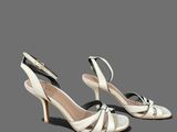 a pair of women ' s white high heeled shoes on a grey background