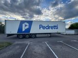Le camion est garé sur un parking, avec un ciel nuageux en arrière-plan.