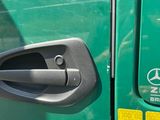 a close up of a door handle on a green truck