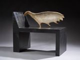 a sculpture of a bird sitting on a bench