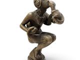 bronze figurine of a man holding a football ball on a pedestal