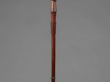 an old wooden walking stick with a wooden handle on a stand