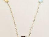 a close up of a necklace with three different colored stones on it