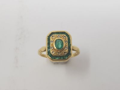 a close up of a gold ring with a green stone