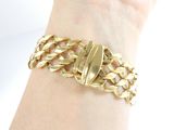 gold chain bracelet with a gold clasp on a woman ' s wrist