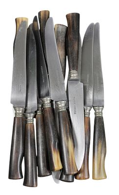 Suite de 12 COUTEAUX DE TABLE, manche en corne brune, lames …