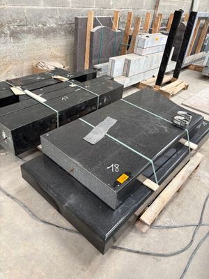 several pieces of black granite are stacked on pallets in a warehouse