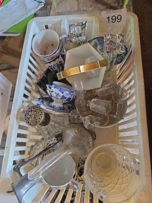 un panier blanc rempli d'assiettes et de tasses posé sur une table