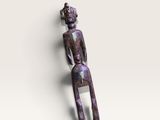 un gros plan sur une figurine représentant une personne assise sur une surface blanche