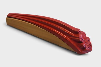 a red object on a white surface with a red handle