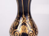 a blue and gold vase sitting on a white surface