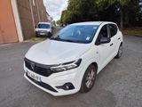une voiture blanche garée dans un parking à côté d'un bâtiment