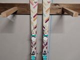 une paire de skis posée sur une étagère en bois près d'un mur