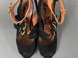 pair of women ' s black sued shoes with gold buckles