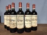 four bottles of wine are lined up on a table