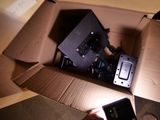 une personne tenant un téléphone portable dans une boîte en carton