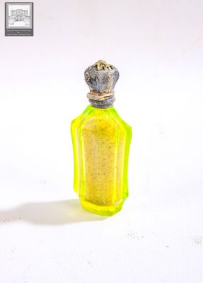 une petite bouteille jaune surmontée d'une couronne