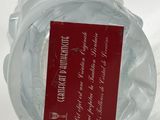 a clear glass bowl with a red label on it