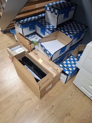 a pile of boxes sitting on the floor next to a printer