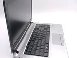 a silver laptop with a black keyboard sitting on a white surface