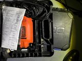 a black and orange drill in a black case on the floor