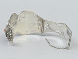 a silver bracelet with an orange bead on it