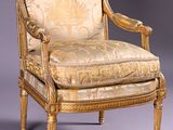 an antique chair with a gold upholstered upholstered back and arms