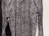 a black and white shirt hanging on a hanger next to a black and white shirt