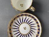 a cup and saucer with a blue and gold decoration