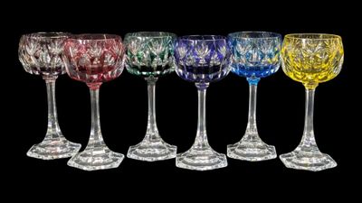 six verres à vin de couleurs différentes sont alignés