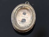 a close up of a pocket watch on a black surface