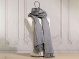 a gray scarf on a mannequin in a room