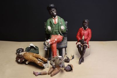 three figurines of people sitting on a table