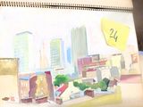 une peinture représentant un paysage urbain sur laquelle est collé un post-it
