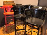 de nombreuses chaises et tabourets dans un coin de la pièce