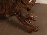 a wooden table with carved animals on top of it