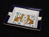a picture of a blue and white plate with two cheetah cats on it