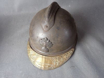 a metal helmet with a gold decoration on it
