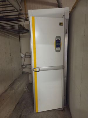 un réfrigérateur blanc dans une pièce ornée d'une bande jaune