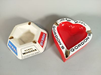 un cendrier rouge en forme de cœur posé à côté d'un cendrier blanc