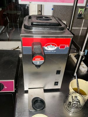 an image of a coffee machine with a cup next to it