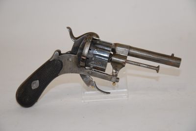 an old revolver with a black handle on a white surface
