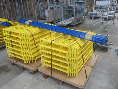Des palettes jaunes et bleues sont empilées les unes sur les autres dans un entrepôt