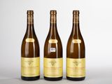 trois bouteilles de vin posées l'une à côté de l'autre sur une table
