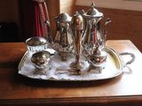 a silver tray with a silver tea set on it