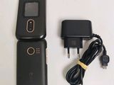 a black cell phone and charger next to each other