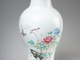 un vase blanc avec des fleurs et des oiseaux peints dessus